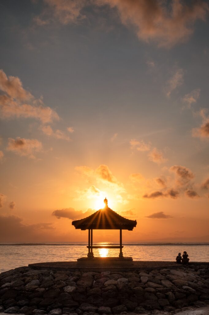 Sunshine over pavilion on jetty at coastline in morning